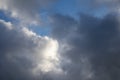 Dark storm clouds with soft sunlight breaking through creating dramatic sky background Royalty Free Stock Photo