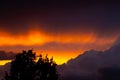 Dark storm clouds during sunset and silhouette of tree with dramatic sky and vibrant colors Royalty Free Stock Photo