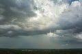 Dark stormy clouds forming on gloomy sky before heavy rainfall over suburban town area