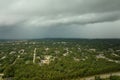 Dark stormy clouds forming on gloomy sky before heavy rainfall over suburban town area