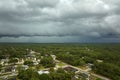 Dark stormy clouds forming on gloomy sky before heavy rainfall over suburban town area