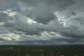 Dark stormy clouds forming on gloomy sky before heavy rainfall over suburban town area