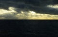 Dark Stormy Sky with Golden Sunshine Rays, Cargo Ship Royalty Free Stock Photo