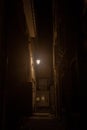 Dark street, an impasse in a dead end back street, with a dim orange light, surrounded by residential buildings in a typical old c