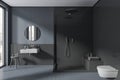 Dark stylish tile home bathroom interior with douche and sink, accessories