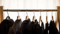 Dark suit jackets on hangers in front of a white background