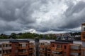 Dark summer storm clouds over residential city buildings and rooftops. Royalty Free Stock Photo