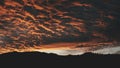 Dark sunset over mountain range silhouette aerial. Sun set above wild nature landscape. Dramatic sky Royalty Free Stock Photo