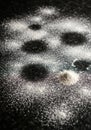 A dark surface covered with scattered white powder. The powder forms a dusting over Royalty Free Stock Photo