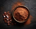 dark table with homemade chocolate and cocoa powder on it.