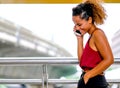 Dark tan skin mixed race woman with smiling call to someone and talk with her mobile phone, also stand the walk way of sky train Royalty Free Stock Photo