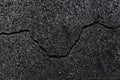 Dark texture of old broken asphalt road or wall big abrasions cracks on the surface pebbles cement in Sofia, Bulgaria, Eastern