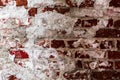 Texture of an old wall of an ancient building with a ruined plaster layer and cracked red bricks, abstract background Royalty Free Stock Photo