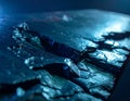 Textured Dark Surface with Cracks and Blue Light Illumination Abstract Background cracked Royalty Free Stock Photo
