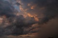 A dark thundercloud on the background of sunset