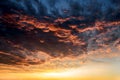 Dark thunderclouds with red orange reflections of the setting sun. Scenic storm clouds lit by the last rays of the sunset. Royalty Free Stock Photo