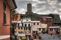 Dark town of Vernazza with people on an old tower ruins on a background.
