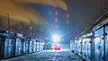 Dark urban downtown city alley at night with garbage trash bins, car garage doors. low light Royalty Free Stock Photo