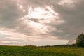Dark wallpaper with dramatical sky and clouds before the storm over the green field Royalty Free Stock Photo