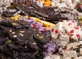 Dark, white and colors chocolate pieces crushed and cocoa beans, culinary background