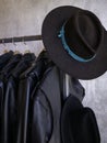 Vertical: Retail fashionable coat rack display with wide brimmed hat.