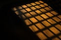 Dark window bars shadow on the wooden floor in prison