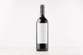 Dark wine bottle with blank white label on white wooden board, mock up. Royalty Free Stock Photo