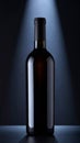 Dark Wine Bottle Under Spotlight on Gray Textured Surface Against Dark Backdrop Royalty Free Stock Photo