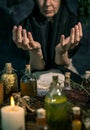 Dark Witch at work: black magic woman makes the witchery by mixing herbs, casting the spells, running magic rituals Royalty Free Stock Photo