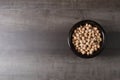 Dark wood casserole with uncooked chickpeas on a wooden board