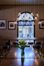 Dark wood table with fresh cut flowers and edison pendant lights Royalty Free Stock Photo