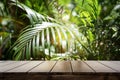 Dark wood table top Bar with blur on green palm leaves or tree in tropical forest with bokeh light at background Royalty Free Stock Photo