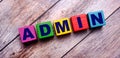 On a dark wooden background, multicolored bright wooden cubes with the text ADMIN Royalty Free Stock Photo