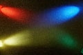 On a dark yellow gradient background in fine grain cross beams of blue red green and yellow gradient light Royalty Free Stock Photo