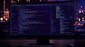 Darkly Lit Computer Monitor Displaying Complex Lines of Code in a Modern Office Setting Royalty Free Stock Photo