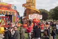 Fun fair carnival in a field with people, helter skelter and other rides