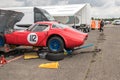 Classic racing car recieving mechanical work in paddock