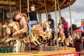 People riding on carousel horse on fairground ride