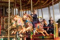 People riding on carousel horse on fairground ride