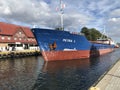 Darlowko, Poland: Cargo ship leaving the port on a summer day Royalty Free Stock Photo