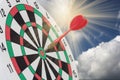 Dart arrow hitting in bullseye on dartboard with sky Royalty Free Stock Photo