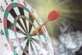 Dart arrow hitting in bullseye on dartboard with smoke. Hot business Royalty Free Stock Photo