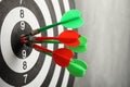 Dart board with arrows hitting target on grey wall,