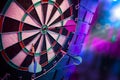 Dart board on a brick wall with dramatic lighting