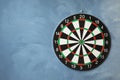Dart board hanging on textured wall. Space for text Royalty Free Stock Photo