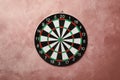 Dart board hanging on pink wall Royalty Free Stock Photo