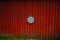 Dart board hanging on a red wooden wall.. Royalty Free Stock Photo