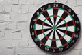 Dart board hanging on white textured wall Royalty Free Stock Photo