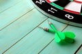 Dart board with two darts lies on a wooden background Royalty Free Stock Photo