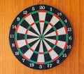 A dart disc in front of a wooden wall Royalty Free Stock Photo